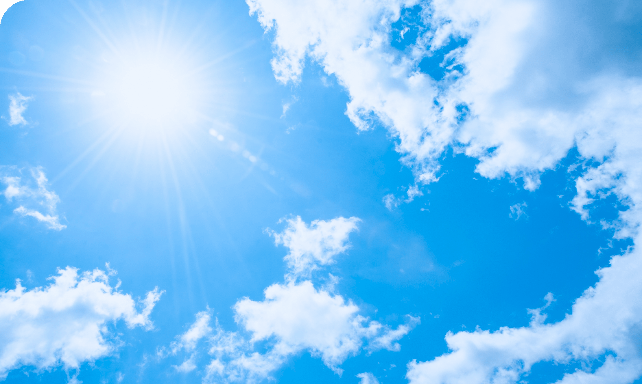 澄みきった青空と雲と太陽の写真