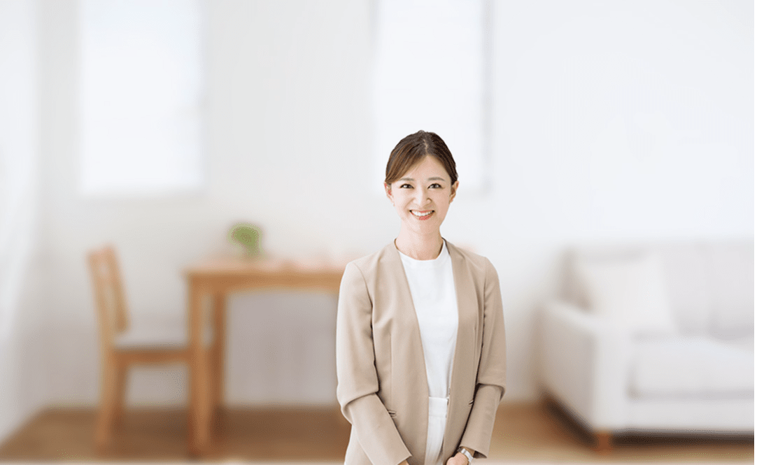 リビング背景にベージュのジャケットを着た笑顔のファイナンシャルプランナーとサポートメッセージが書かれた写真
