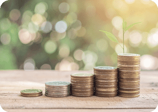 キラキラと輝いた背景で木のテーブルの上にお金が5段階段上に積まれた写真